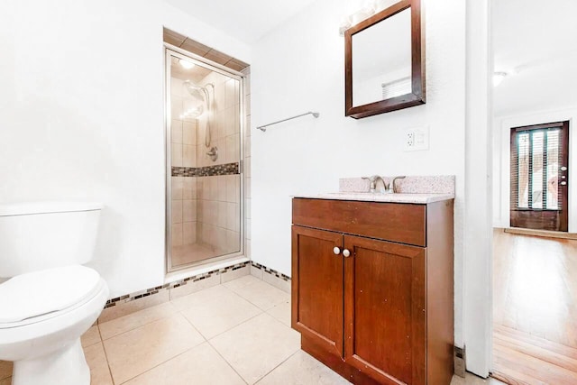 full bathroom with a shower stall, baseboards, toilet, tile patterned floors, and vanity