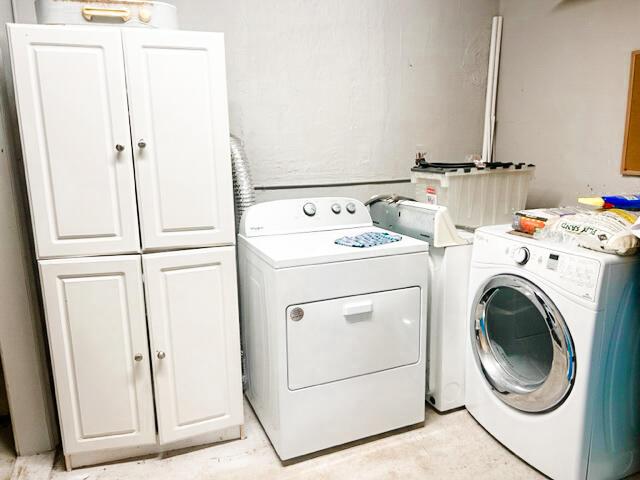 washroom with cabinet space and washer and clothes dryer