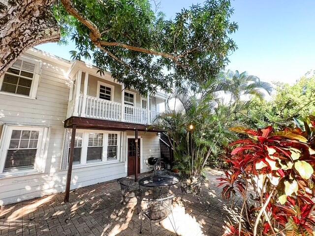 rear view of property featuring a patio area and a balcony