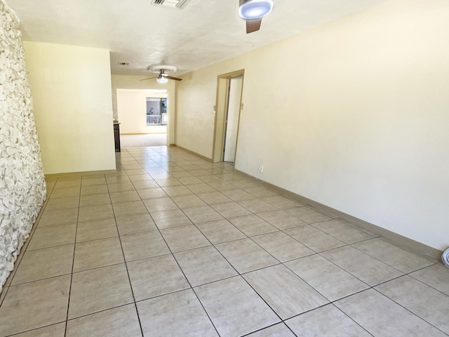 spare room featuring light tile patterned floors, visible vents, and ceiling fan