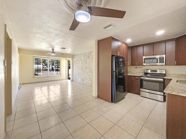 kitchen featuring light tile patterned floors, visible vents, appliances with stainless steel finishes, and open floor plan