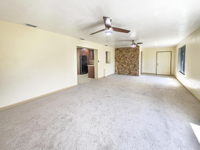 interior space with visible vents, light colored carpet, a textured ceiling, and baseboards