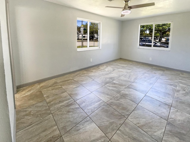 unfurnished room with baseboards and ceiling fan