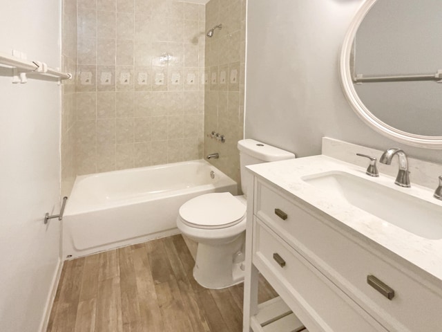 bathroom featuring vanity, bathing tub / shower combination, toilet, and wood finished floors