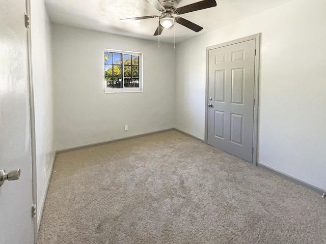 unfurnished room with baseboards, carpet, and a ceiling fan