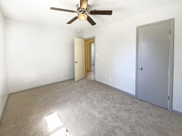 unfurnished bedroom with baseboards, light colored carpet, and ceiling fan