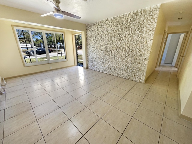 spare room with light tile patterned floors and a ceiling fan