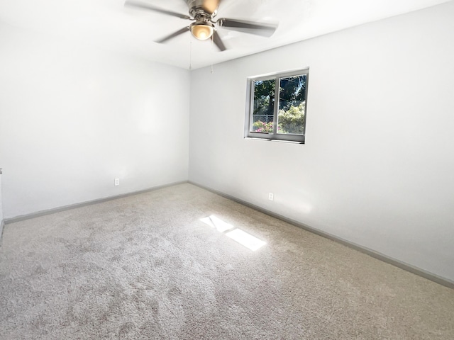 empty room with carpet flooring, ceiling fan, and baseboards