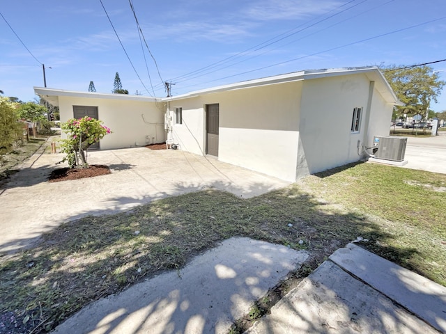 back of house featuring stucco siding, central AC, and a patio area