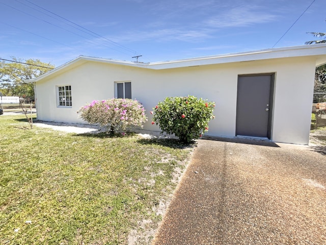 view of front of house featuring a front yard and stucco siding