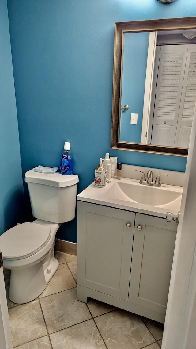 bathroom featuring toilet, vanity, and baseboards