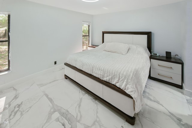 bedroom with baseboards and marble finish floor