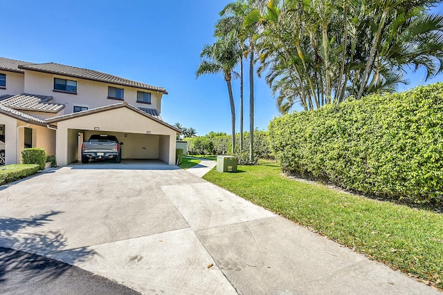 view of side of property with a yard, driveway, and stucco siding