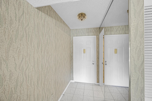 interior space with light tile patterned flooring and a textured ceiling