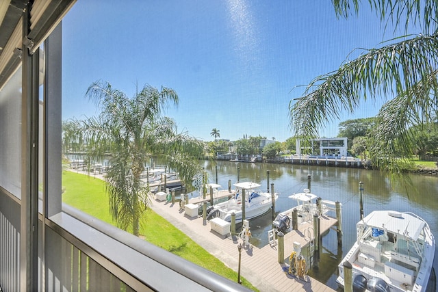 dock area with a lawn, a water view, and boat lift