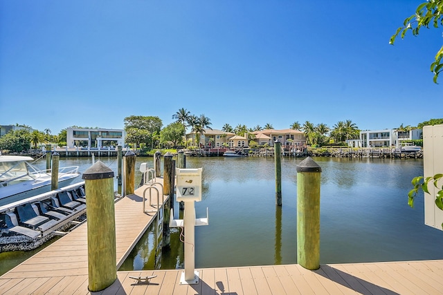 view of dock with a residential view and a water view