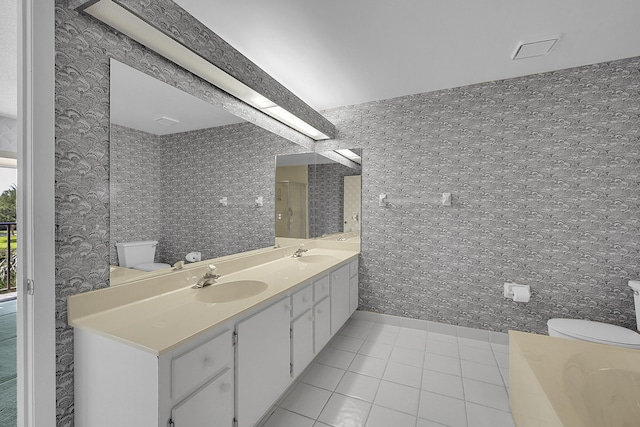 bathroom featuring wallpapered walls, tile patterned floors, toilet, and a sink