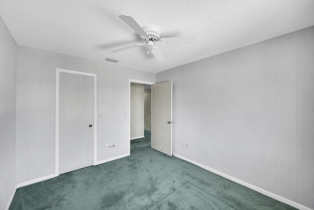 unfurnished bedroom with visible vents, a textured ceiling, carpet, baseboards, and ceiling fan