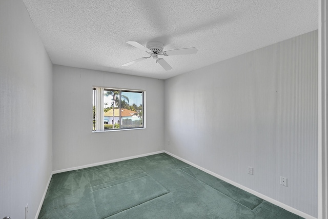 unfurnished room with baseboards, a ceiling fan, dark carpet, and a textured ceiling