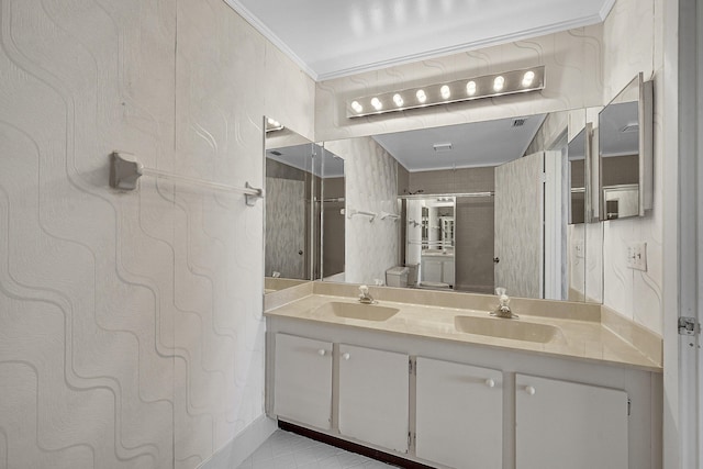 full bathroom with double vanity, ornamental molding, a shower, and a sink