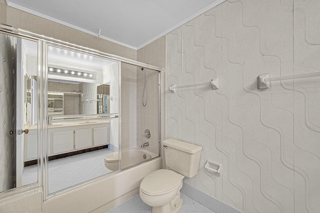 bathroom with toilet, ornamental molding, combined bath / shower with glass door, tile patterned flooring, and vanity