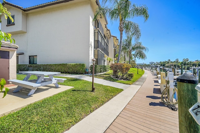 view of community featuring a lawn and a boat dock