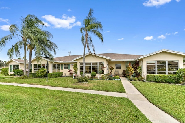 view of front of property featuring stucco siding and a front lawn