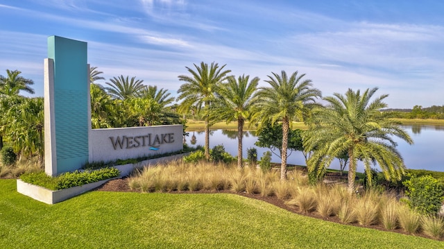 community sign featuring a yard and a water view