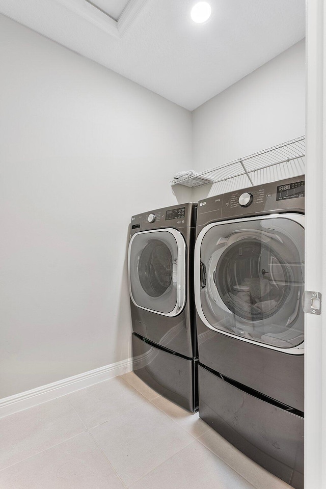 laundry area featuring washer and dryer, baseboards, laundry area, and tile patterned flooring