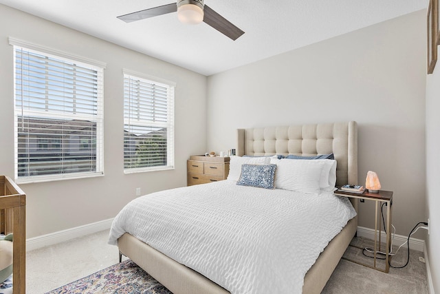 carpeted bedroom with a ceiling fan and baseboards