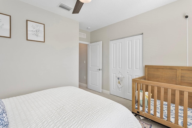 bedroom featuring ceiling fan, visible vents, a closet, and light carpet