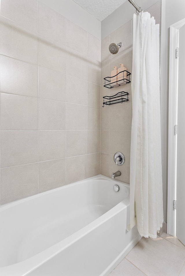 bathroom featuring shower / bathtub combination with curtain and a textured ceiling