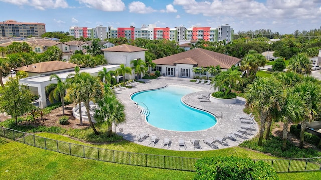 pool featuring a city view, a patio area, and fence