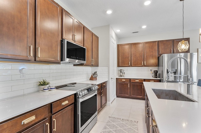 kitchen featuring visible vents, a sink, backsplash, appliances with stainless steel finishes, and light tile patterned floors