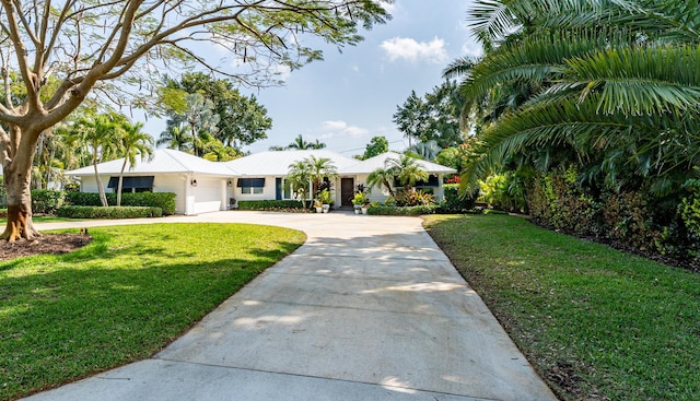 view of front of house with concrete driveway, an attached garage, and a front yard