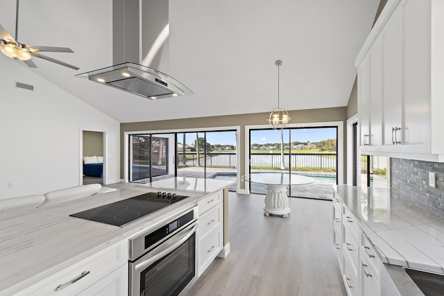 kitchen featuring oven, light stone counters, an inviting chandelier, black electric stovetop, and extractor fan