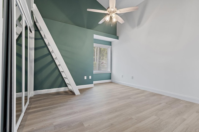 unfurnished room featuring ceiling fan, baseboards, and wood finished floors