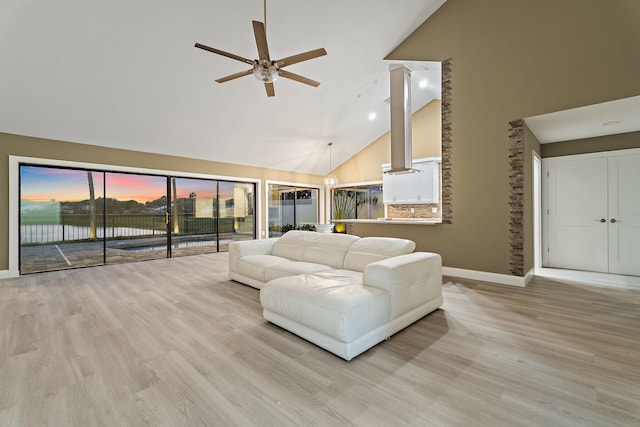 living room featuring high vaulted ceiling, a ceiling fan, baseboards, and wood finished floors