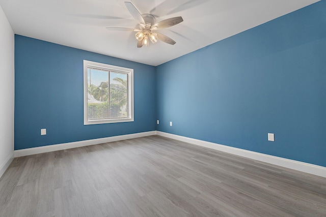 empty room featuring a ceiling fan, baseboards, and wood finished floors