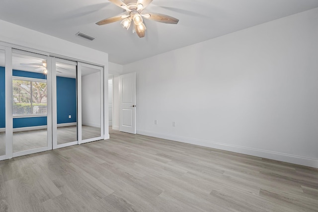 unfurnished bedroom featuring a ceiling fan, baseboards, visible vents, and light wood finished floors