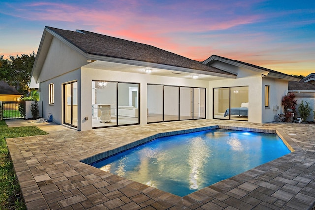 rear view of property with a patio area, stucco siding, and fence