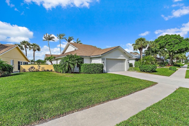 view of front of home with a front lawn, fence, concrete driveway, stucco siding, and a garage