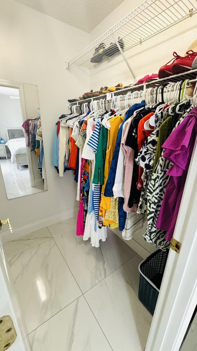 walk in closet with marble finish floor