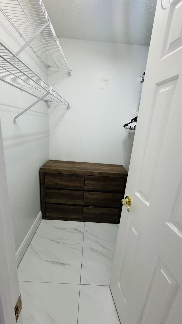 spacious closet with marble finish floor