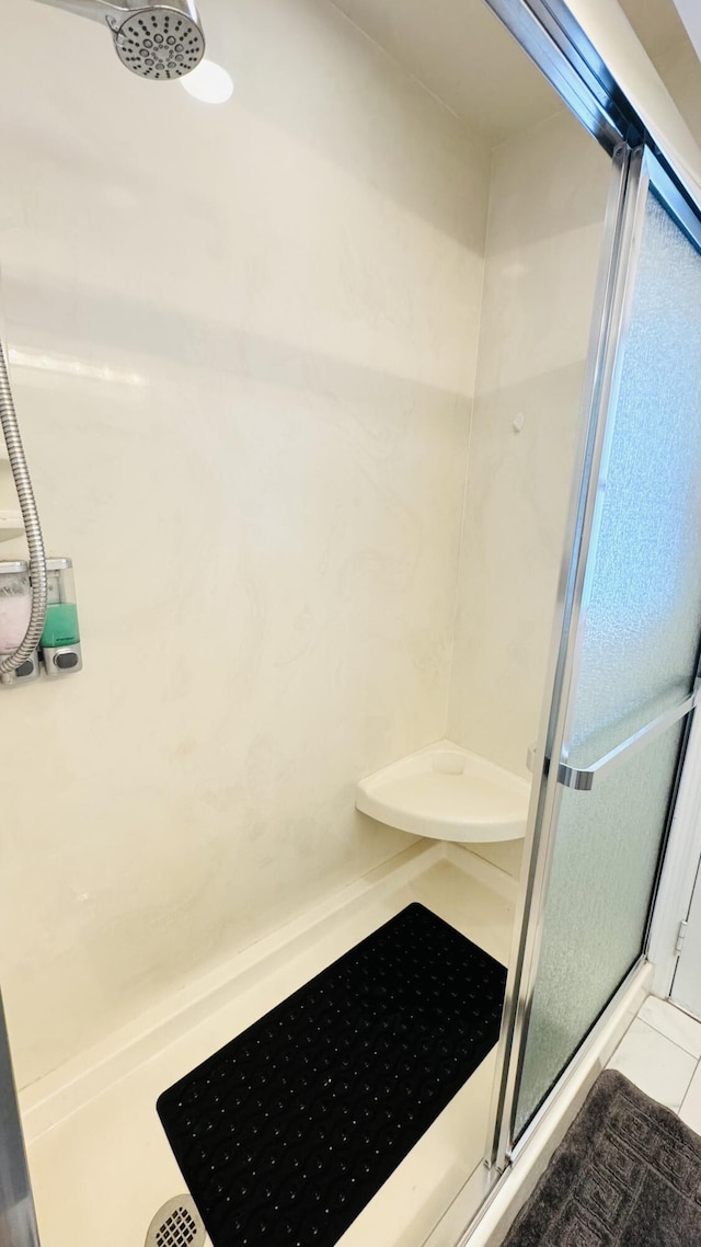 bathroom with tile patterned flooring and a stall shower