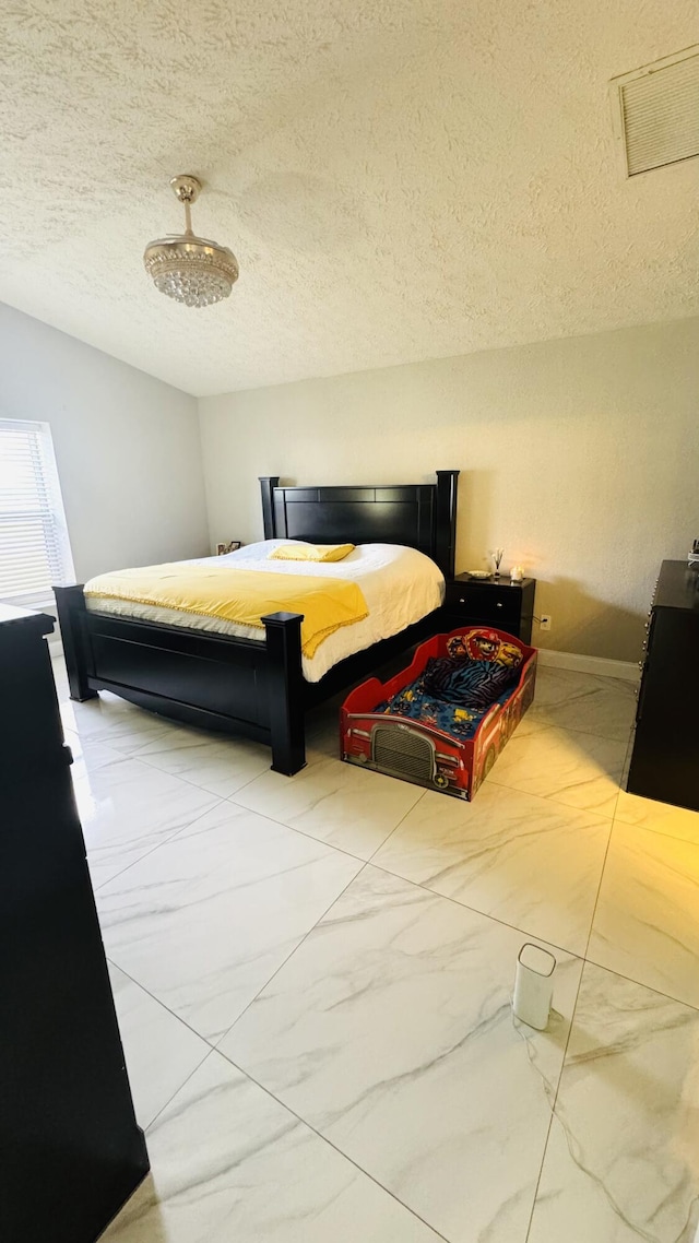 bedroom featuring visible vents, baseboards, a textured ceiling, and marble finish floor