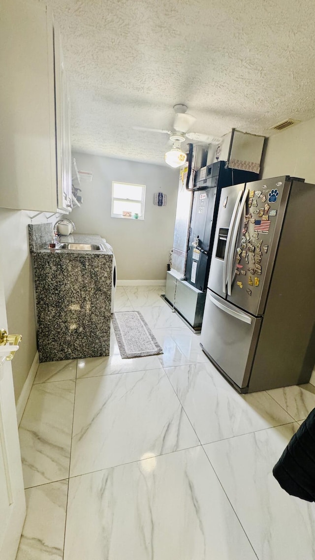 kitchen featuring visible vents, marble finish floor, a sink, stainless steel fridge with ice dispenser, and ceiling fan