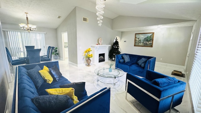 living room featuring an inviting chandelier, lofted ceiling, a fireplace with raised hearth, and visible vents