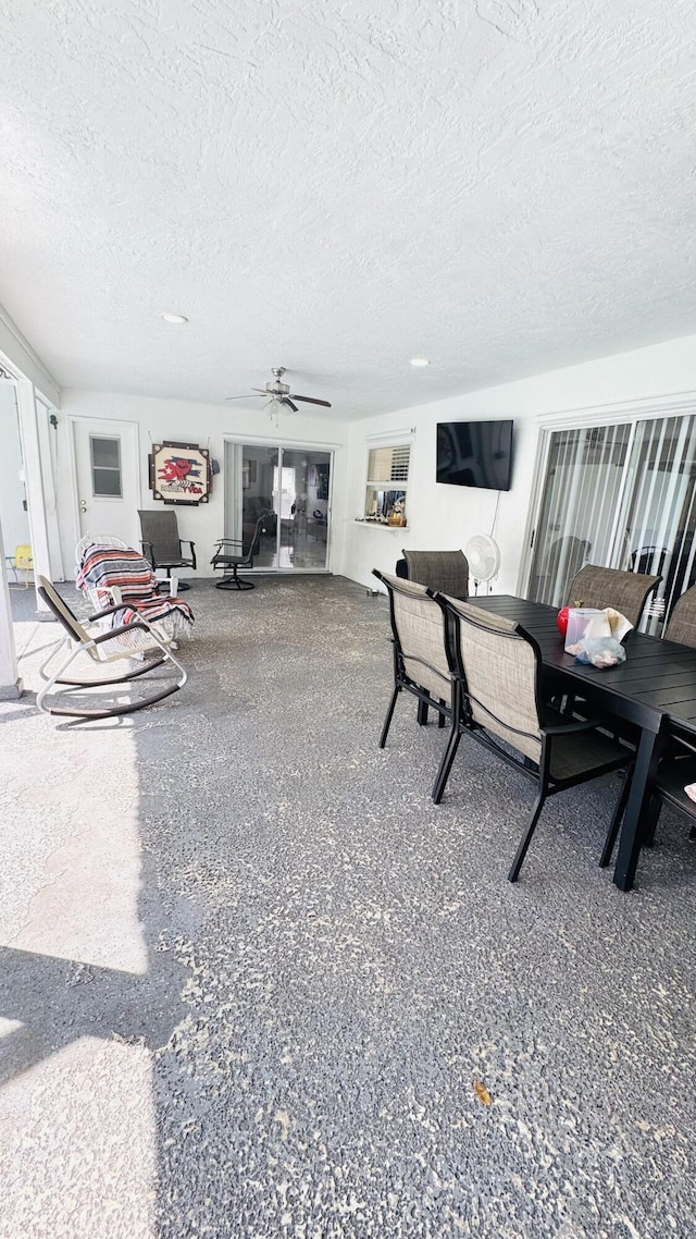 dining space featuring a textured ceiling, speckled floor, and ceiling fan