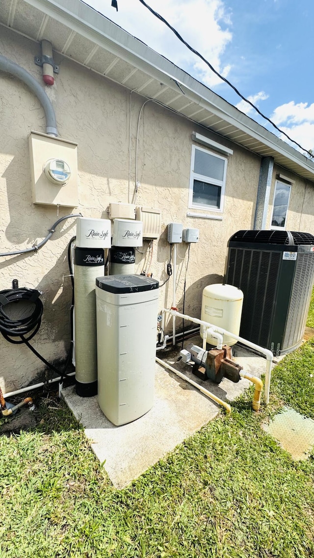 details with central air condition unit, stucco siding, and electric meter